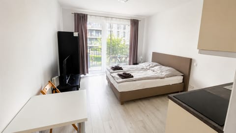 Bright modern studio with balcony access, kitchenette, and cozy double bed