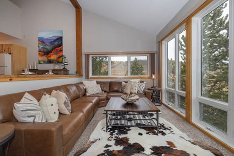 Sink into comfort on plush leather sectionals while soaking in stunning mountain views through floor-to-ceiling windows. Your perfect retreat blends rustic warmth with natural beauty.