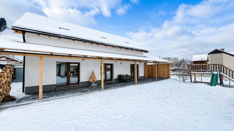 Snowy retreat with covered patio, spacious yard, and family-friendly outdoor space