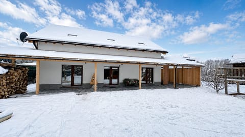 Snowy backyard retreat with covered patio and cozy chalet charm