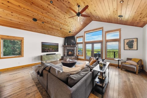Sierra Sky Lodge: Vaulted living room with stone fireplace and mountain views.