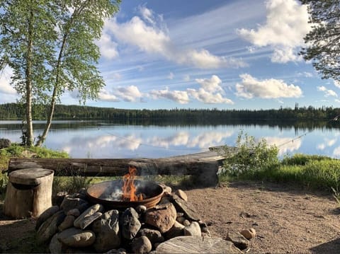 Lakeside fire pit with a bench and open views across the lake.