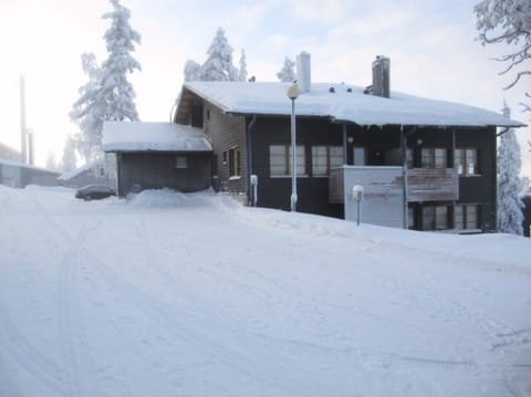 Exterior view of the apartment building and outdoor storage on a snowy winter day.