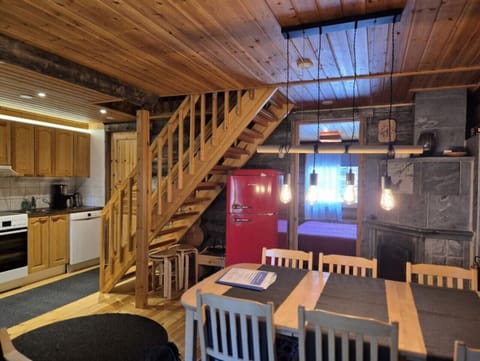 Open-plan kitchen and dining area with a table for six, beside the wooden staircase to the upper floor.