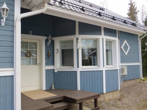 Exterior view of the blue semi-detached apartment with its own covered entrance.