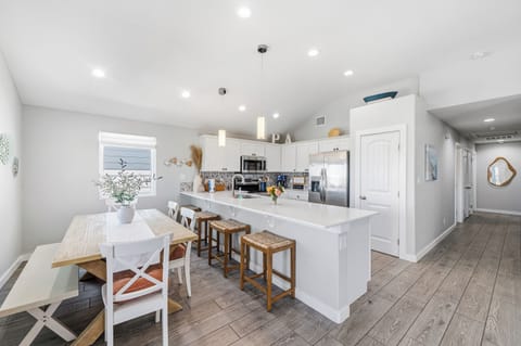 Step into your bright, open kitchen where fresh flowers and coastal touches welcome you home. The breakfast bar is perfect for morning coffee, while the dining nook invites shared meals and laughter.
