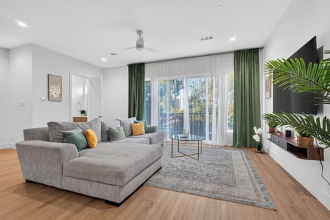 Bright modern lounge with large sectional, balcony doors, and natural light