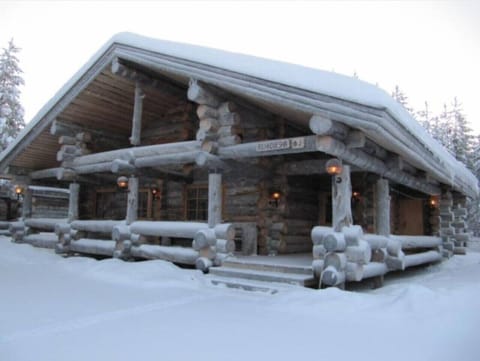 The log villa under a thick blanket of snow in winter.
