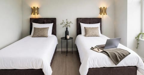 Flexible box-spring beds arranged as two singles, with a shared table and laptop-friendly space