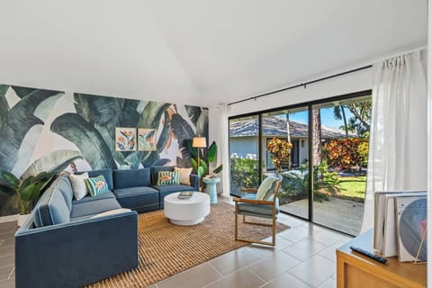 Bright, open living space with a plush sectional & floor-to-ceiling glass doors.