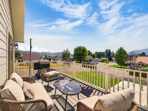 A large Deck looking West at the Wasatch Range with outdoor seating and a large Traeger BBQ under the open sky