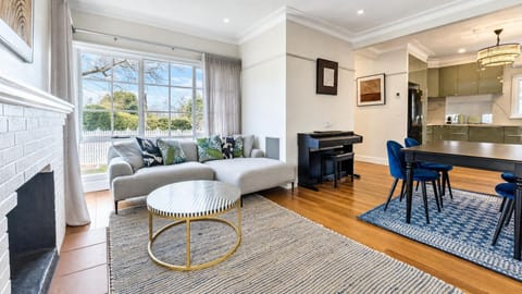 Bright living area with a fireplace opening into the dining space.