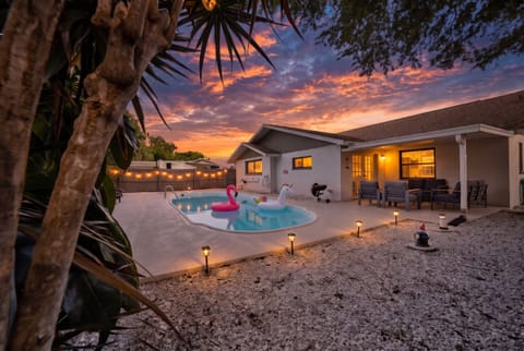 Long after the flights and the sand are forgotten, this is the frame your family will still describe: warm sky, lit pool, string lights over the water, everyone barefoot and no reason at all to go anywhere else tonight.