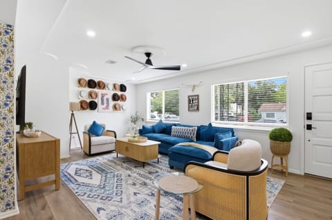 Spacious Living Room with 65 inch Smart TV, modern furnishings, and seating for the whole group. Open layout flowing to the Dining Room and Kitchen.

