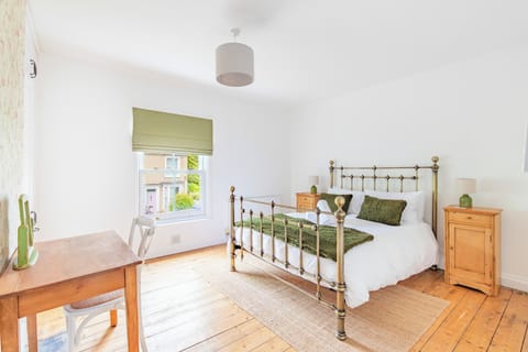 Bedroom one is a bright, character filled room with a brass framed king size bed, original wooden flooring and a charming street view, a lovely spot to wake up in.