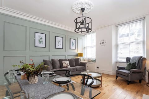 Settle into a bright, welcoming living room where soft seating, warm wooden floors and thoughtful styling create an easy space to unwind after a day exploring Grange over Sands.