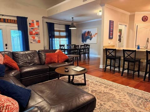 Gather with friends and family in this bright, open living space. Whether you're lounging on the sectional, enjoying a meal at the dining table, or grabbing a quick bite at the kitchen bar, you’ll feel right at home watching the big-screen TV.