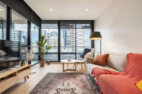 The living room showcases floor-to-ceiling windows revealing impressive city views.
