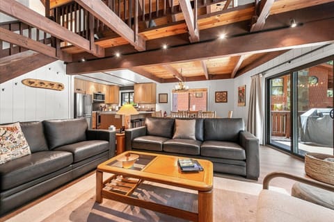 Relax under soaring wood beams in your open-concept living space, where plush leather sofas and warm tones create the perfect retreat after a day of adventure.