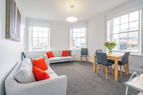 Share breakfast beside the tall sash windows or claim a sofa with a book in the living area, where abundant daylight and generous seating lend the room a cheerful city-home feel.