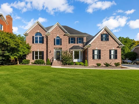 Elegant brick home with manicured lawn and standout curb appeal