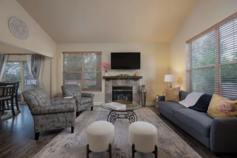 Settle into the living room with comfortable seating, a fireplace, and TV, with the dining area conveniently connected just beyond.