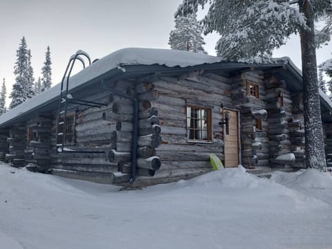 Traditional kelo log exterior surrounded by deep snow and pine forest.