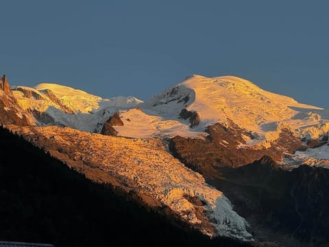 Au coucher du soleil, les sommets s’embrasent d’or et de cuivre, transformant le balcon en balcon sur l’éternité.