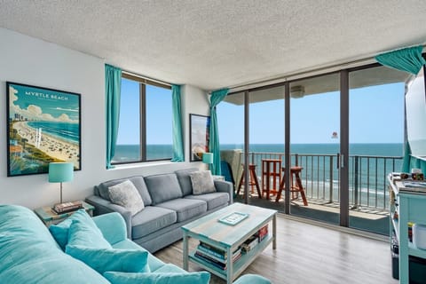 Sink into plush coastal-inspired seating and watch the ocean stretch endlessly before you through expansive glass doors—this is your front-row seat to endless waves and fresh sea air.