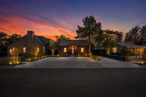 Stunning sunset curb appeal with warm lighting and a spacious driveway