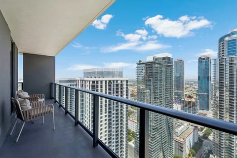 Private balcony featuring high-rise city views and comfortable seating.