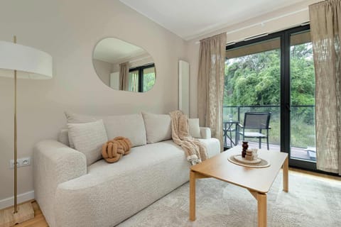 Cozy sofa area with a coffee table and views of greenery.