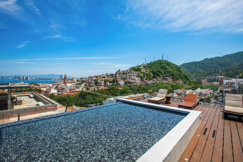 Soak in your rooftop pool while taking in sweeping views of the colorful hillside town, lush mountains, and sparkling ocean beyond—a perfect setting for unforgettable vacation moments.
