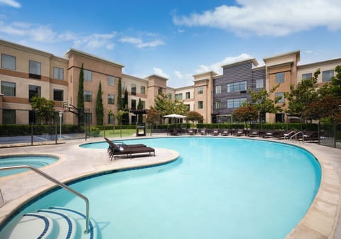 Elegant view of the poolside area with lounge chairs and well-maintained landscaping.