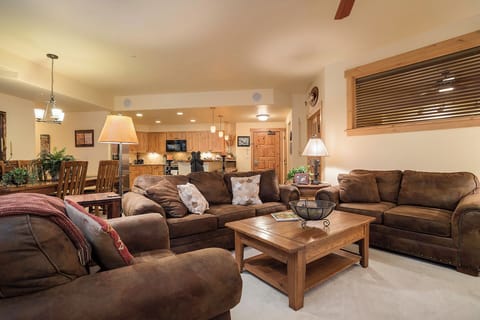 Settle into plush leather sofas in your open-concept living space, where warm wood accents and soft lighting create the perfect backdrop for your mountain getaway conversations.