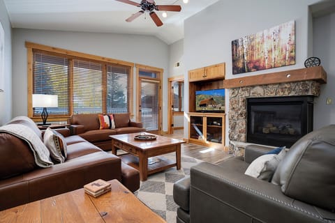 Curl up with loved ones by the stone fireplace. High ceilings, plush leather seating, warm wood tones, and natural light create your cozy mountain retreat.