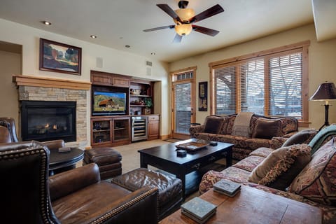 Sink into plush seating beside your stone-faced fireplace after a day of adventure. Large windows fill your living space with natural light, while entertainment awaits at the center of your mountain getaway.