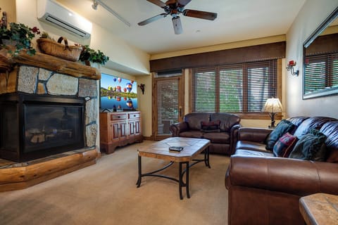 Unwind in your inviting living space, where plush leather seating and a warm stone fireplace create the perfect ambiance for relaxation after a day of adventure.