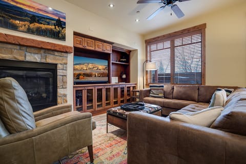 Sink into plush leather seating by your private fireplace, perfect for unwinding after a day exploring the mountains. The entertainment center and warm wood accents create your cozy retreat.