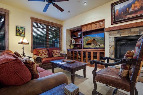 Settle into this warm living room where you can unwind by the fireplace, enjoy your favorite shows on the large TV, and relax on plush seating with mountain views just outside your window.