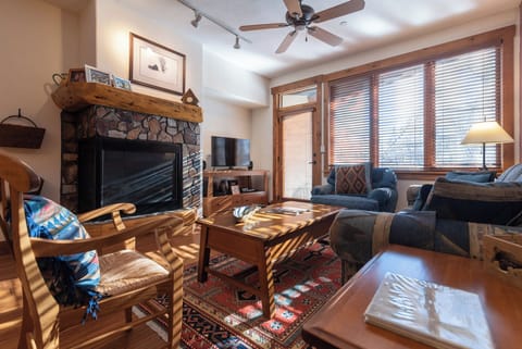 Settle into your cozy living room where sunlight filters through the windows and the stone fireplace awaits to warm your mountain evenings. Sink into plush seating after a day of adventure.