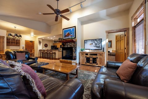Sink into plush leather seating and unwind in your spacious living area, where a stone fireplace and warm wood tones create the perfect mountain retreat atmosphere.