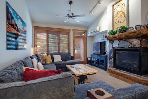 Curl up on the plush sectional and enjoy cozy evenings by the stone fireplace, with rustic wood details, a smart TV for your entertainment, and air conditioning for year-round comfort.