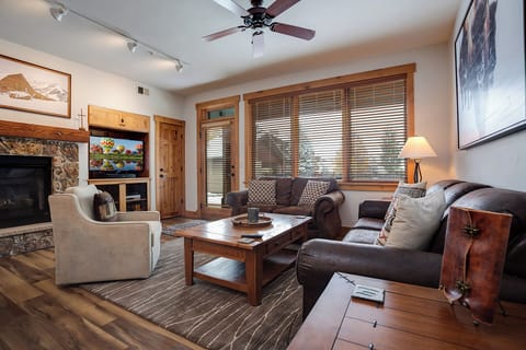 Cozy up in your inviting living room with plush leather sofas, a warm fireplace, and mountain views. Perfect for unwinding after a day of adventure.