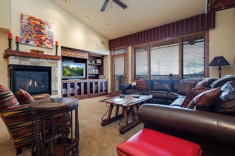 Sink into plush leather sofas beside a warming fireplace and enjoy your favorite shows in this thoughtfully designed living space with stunning mountain views.