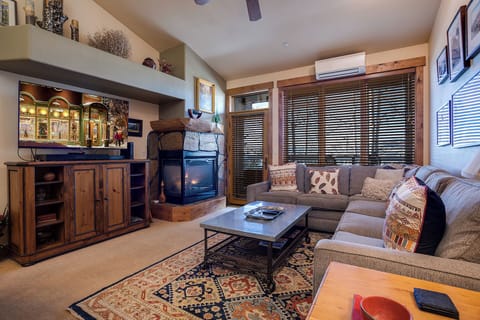 Settle into your inviting living room with a cozy fireplace, plush sectional sofa, and warm wood accents perfect for relaxing evenings after a day of adventure.