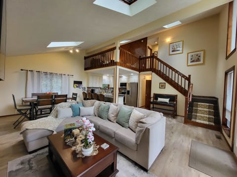 Vaulted ceilings and a wall of windows fill this living room with natural light, plenty of room for the whole group to unwind.