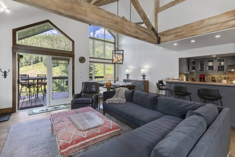 Living room: Large open-concept living area with an extremely large velvet sofa, 60” Samsung Smart TV, and electric fireplace