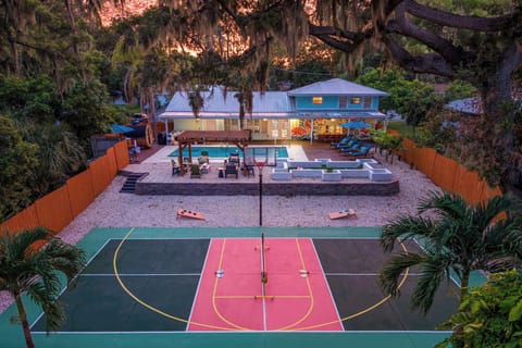 Sport court in the foreground, pool and lounge space beyond — seen from above at sunset, this backyard shows off everything it has to offer.