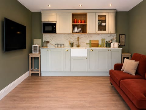 Kitchen which has a fridge, microwave and hot plate.  